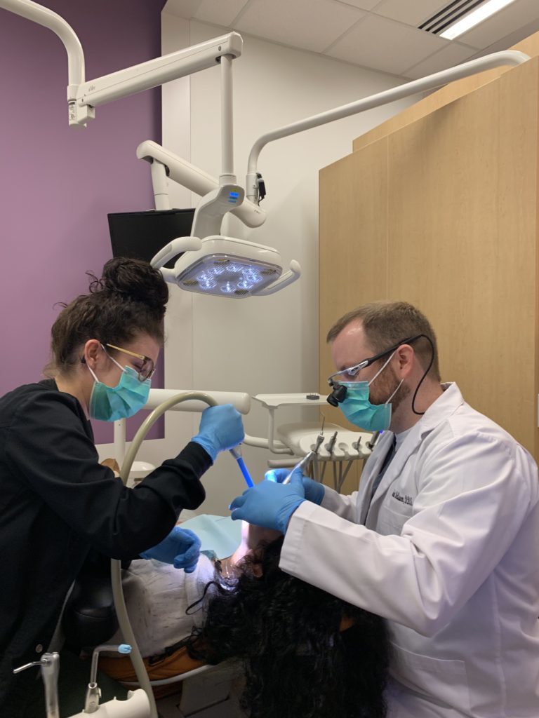 Dr. McQueen providing emergency dentist service for a chipped tooth to a patient at the Fayetteville, AR office of McQueen Dental.