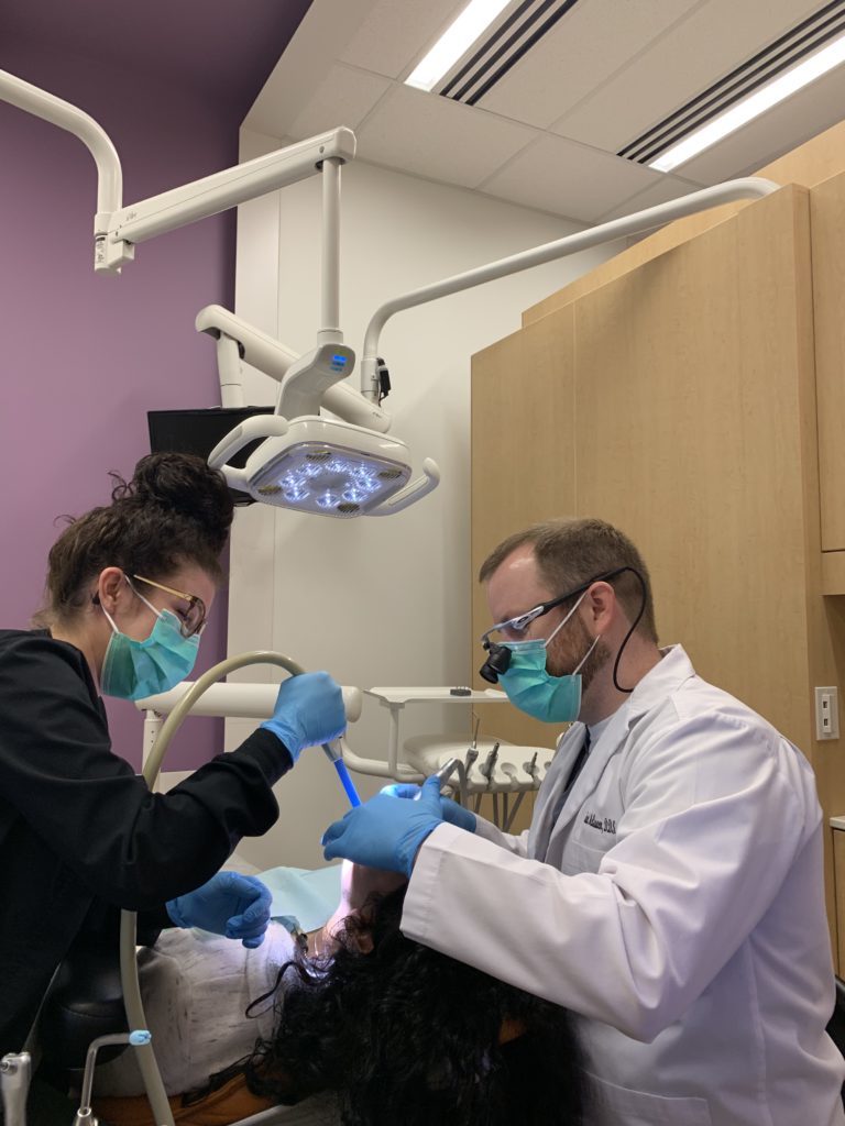 Dr. McQueen working on a patient providing dental services at McQueen Dental in Fayetteville, AR.