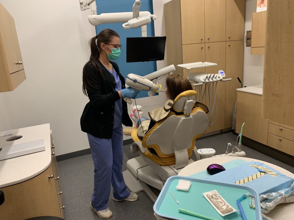Hygienist examining patient's teeth during an emergency exam